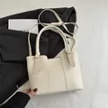 Chic beige lychee grain leather tote bag with dual handles and adjustable shoulder strap - White