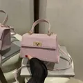 Pink glitter mini handbag with golden turn-lock closure and dual strap design - Pink