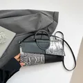 Elegante Handtasche mit grauem Schlangenmuster und schwarzem Griff und Schultergurt - Schwarz und Weiß