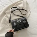 Chic black crossbody bag with white contrast stitching and silver M logo detail - Black