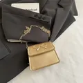 Mini borsa a sella dorata con fiocco in metallo e tracolla a catena da donna - Oro