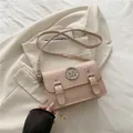Minimalist light pink square satchel with silver M logo and dual buckles on soft blazer - Pink