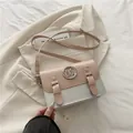 Pink and silver contrast messenger bag with large metal M logo and leather shoulder strap - Pink White
