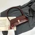 Minimalistische Vintage-Schultertasche aus glänzendem dunkelbraunem Leder mit Goldschloss - Rotbraun