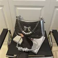 Fashionable black sequin underarm bag with silver bow charm and pearl chain detail - Black