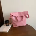Bolso tote rosa minimalista de cuero PU suave presentado en una mesa de madera - Rosa