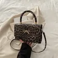 Handtasche mit Leopardenmuster, goldener Schleife und praktischem Schultergurt - Braun