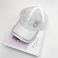 Detailed close-up of white floral lace baseball cap with rhinestone bear and pearl heart - Adult, Adjustable / White