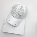 Close-up of intricate white lace pattern and sparkling butterfly rhinestone on the cap - One Size / White