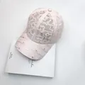 Detailed close-up of a pink lace baseball cap with shimmering rhinestones and a bow knot - One Size / Pink