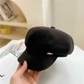Close-up of black wool newsboy hat with PU leather brim and a gold metal side accent - M / Black