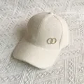Detalle de gorra de béisbol de piel sintética beige con logotipo metálico dorado - Talla Adulto (Ajustable) / Blanco