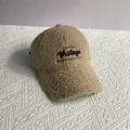 Primo piano del berretto in lana di agnello kaki con ricamo di lettere vintage - Taglia Adulto (Regolabile) / Beige