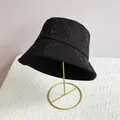 Detail of black bucket hat with rhinestone M pattern and wide brim on a gold stand - Black/Black Zirconia / M (56-58cm)