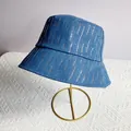 Detail van donkerblauwe denim vissershoed met zilveren strass-steentjes op metalen standaard - M (56-58cm) / Denim Blauw