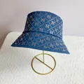 Detail of blue denim bucket hat featuring sparkling rhinestone N pattern on a display stand - M (56-58cm) / Blue Denim