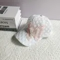 Detailed view of white lace baseball cap featuring pink 3D butterfly with pearl beading - Adult, Adjustable / White Plum Flower Style
