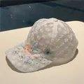Detail of white mesh baseball cap featuring lace flowers, pearls and butterfly embroidery - Lace Butterfly Flower