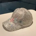 Detail of sequined baseball cap featuring 3D pink floral lace and blue butterfly embroidery - Gold Butterfly Flower