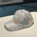Detailed view of white sequined baseball cap with 3D floral lace and pearl embellishments - White Beaded Flower
