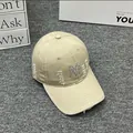 Detail of khaki distressed baseball cap featuring a sparkly rhinestone M letter patch - Adult One Size (Adjustable) / Khaki