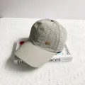 Detail of light gray laser-cut breathable holes and gold metal logo on baseball cap - Adult One Size (54-59cm) / Gray
