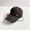 Close-up of black breathable baseball cap with laser-cut holes and gold metal logo - Adult One Size (54-59cm) / Black