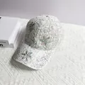 Detail einer weißen Spitzen-Baseballkappe mit glitzernden KISS-Buchstaben und Blumenmuster - Verstellbar (Erwachsene) / Weiß
