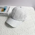 Dettaglio dell'elegante motivo in pizzo floreale bianco su un cappellino estivo traspirante - Taglia Adulto (Regolabile) / Bianco
