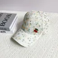 Détail d'une casquette en dentelle florale avec pendentifs cerises rouges décoratifs - Adulte, Réglable / Orange