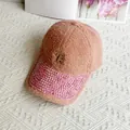 Détail de la casquette rose en peluche avec visière en strass et logo métallique doré R - Adulte, Réglable / Rose avec Strass Roses