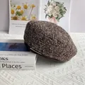 Dettaglio basco in tweed con inserto in metallo su tavolo con libri e riviste d'arte - M(56-58cm) / caffè