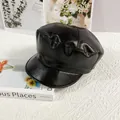 Detailed macro view of black PU leather newsboy cap with lychee texture and fine stitching - M / Black
