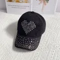 Detailed macro view of black knit baseball cap with sparkling rhinestone heart decoration - Black