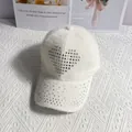 Detail of white plush baseball cap with rhinestone heart and sparkling brim texture - White