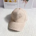 Detailed view of apricot knitted baseball cap featuring sparkling rhinestone heart design - Khaki