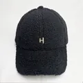 Close-up of black fuzzy sherpa baseball cap featuring beige embroidered letter H detail - Adult Size (Adjustable) / Black