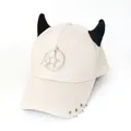 Dettaglio del cappellino punk crema con corna nere e ciondoli a stella con anelli metallici - L (56-60cm) / Beige (Anello Doppie Stelle)