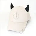 Dettaglio cappellino beige in tela con corna di diavolo nere e ciondolo a forma di aereo - L (56-60cm) / Beige (Anello Aereo)