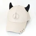 Dettaglio del cappellino beige con corna da diavolo nere e ciondolo della Torre Eiffel - L (56-60cm) / Beige (Anello Torre)