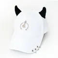 Dettaglio cappello bianco in cotone con corna di demone in peluche nero e anelli metallici - L (56-60cm) / Bianco (Semicerchio Sorriso)