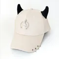 Dettaglio cappello beige con corna da diavolo nere e pendenti con anelli in metallo - L (56-60cm) / Beige (Semicerchio Sorriso)