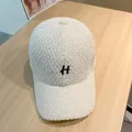 Nahaufnahme der weißen Teddy-Fleece-Baseballkappe mit schwarzer H-Stickerei-Detail - Erwachsenengröße (Verstellbar) / Weiß