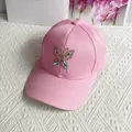 Detailed close-up of pink cotton baseball cap featuring a sparkling rhinestone butterfly - Adult Size (Adjustable) / Pink