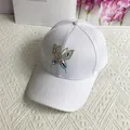 Detailansicht des glitzernden Strass-Schmetterlingsmusters auf einer weißen Baumwollkappe - Erwachsenengröße (Verstellbar) / Weiß