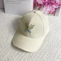 Detail der Strass-Schmetterlingsverzierung auf einer cremeweißen Damen-Baseballkappe - Erwachsenengröße (Verstellbar) / Beige