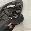 Borsa a tracolla a mezzaluna in pelle nera con fibbia argentata e tracolla sottile - Nero