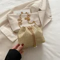 Schicke beige Stroh-Eimertasche mit Goldkette und eleganten Perlen-Kordelzug-Akzenten - Khaki