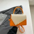 Fashionable orange tote bag with beige woven flap and golden metal accents - Orange