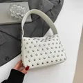 White textured leather shoulder bag featuring silver rivets and a wide top handle - White